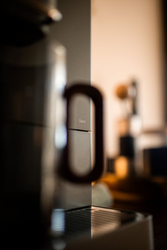 The Demi wordmark framed through the handle of a mug