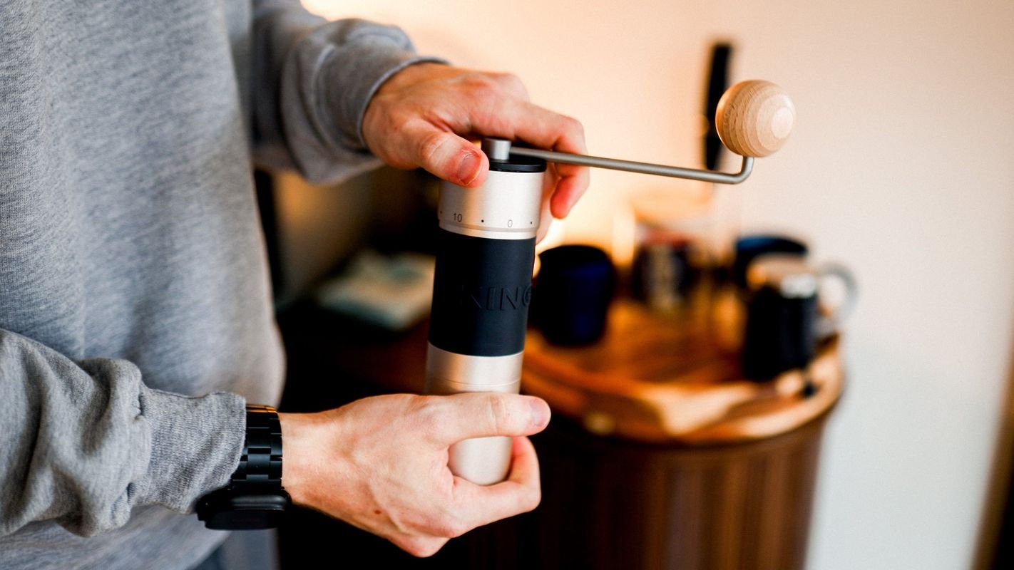 Two hands turning the K6&rsquo;s wooden-knobbed crank
